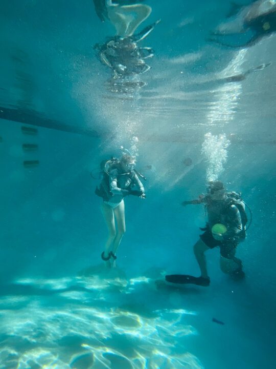 Woman with disabilities scuba diving under water imurs